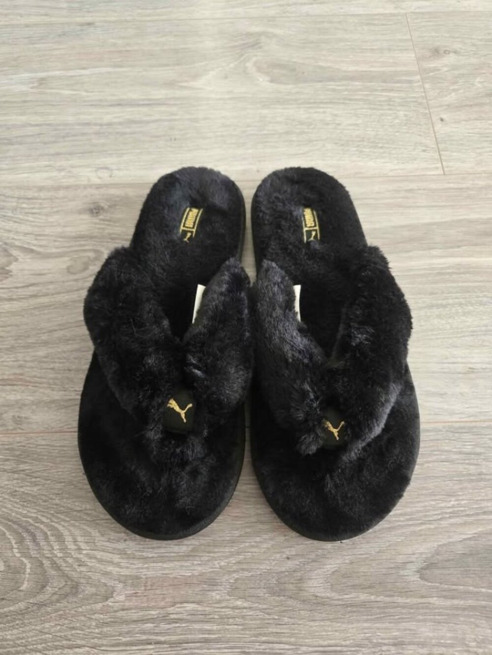 PUMA Fluff Flip Slippers in black and team gold feature a plush size 7